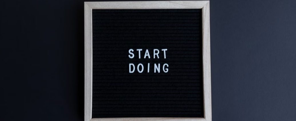 Black letter board with the motivational phrase 'Start Doing' in white text on a gray background.