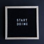 Black letter board with the motivational phrase 'Start Doing' in white text on a gray background.