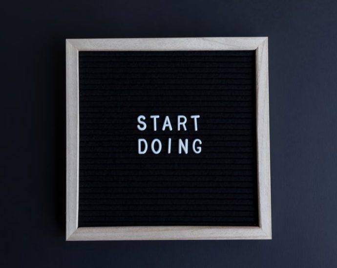 Black letter board with the motivational phrase 'Start Doing' in white text on a gray background.